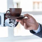 Coffee_is_fuel._Close_up_male_hand_is_taking_cup_of_delicious_espresso_from_robot_in_office