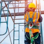Construction_worker_wearing_safety_harness_belt_during_working_at_high_place.