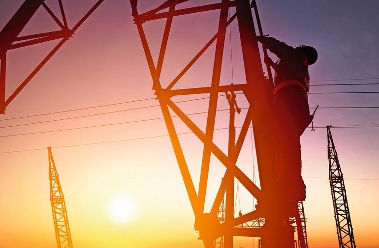 Worker_at_an_electric_substation_with_sunset_background