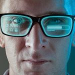 A_close_up_image_of_a_man_wearing_smart_arugmented_reality_glasses_with_virtual_screen_displaying_icons_and_loading_screen_-_modern_technology_concept_image_with_copy_space_for_text.