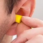 Close-up_Of_Person_Ear_With_Yellow_Earplug