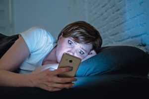 Young_attractive_caucasian_worried_woman_awake_late_at_night_using_smart_phone_lying_in_bed_in_a_dark_bedroom._Using_mobile_in_internet_addiction_mobile_abuse_and_insomnia_concept._Looking_worried