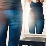 anorexia_concept_-_woman_looks_at_her_fat_reflection_in_mirror