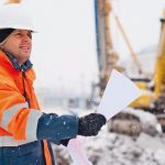 Civil_engineer_at_construction_site_is_inspecting_ongoing_works_according_to_design_drawings_in_difficult_winter_conditions