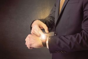 Businessman_wearing_smartwatch_with_shiny_rays_on_it.