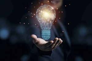 Businessman_holding_drawing_glowing_lightbulb,_creative_thinking_ideas_and_innovation_concept.