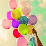 Girl_hand_holding_colorful_balloons._happy_birthday_party._vintage_filter_effect