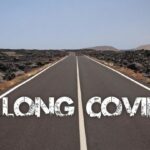View_on_paved_empty_road_through_dry_stony_desert_with_text:_long_covid