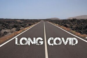 View_on_paved_empty_road_through_dry_stony_desert_with_text:_long_covid